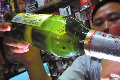 这瓶未开封的燕京啤酒内有一颗黑色悬浮物。京华时报记者 