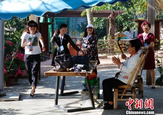 香港海南社团总会领袖回乡考察团成员在中寥村与村民互动娱乐。 